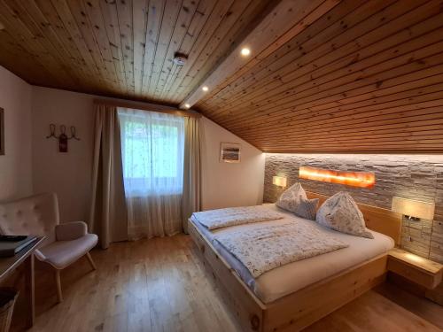 a bedroom with a large bed with a wooden ceiling at Wagnerhof in Pichl bei Aussee