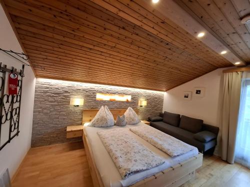 a bedroom with a large bed and a couch at Wagnerhof in Pichl bei Aussee