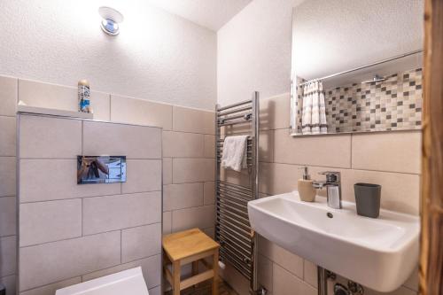 a white bathroom with a sink and a mirror at Family Tree rekreačný dom in Liptovský Mikuláš