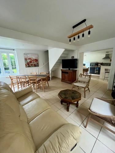 un salon avec un canapé et une table dans l'établissement La Belle des champs - maison avec terrasse, à Courseulles-sur-Mer