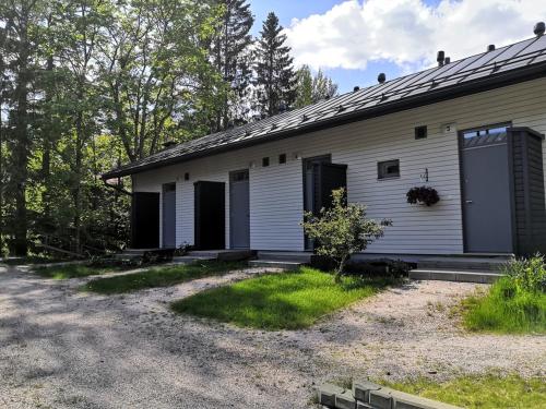 a white building with black doors on the side of it at Huoneisto grillausmahdollisuudella in Espoo