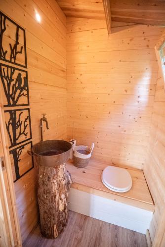 un sauna en bois avec des toilettes et un seau dans l'établissement Champs des Rêves, à Busserolles