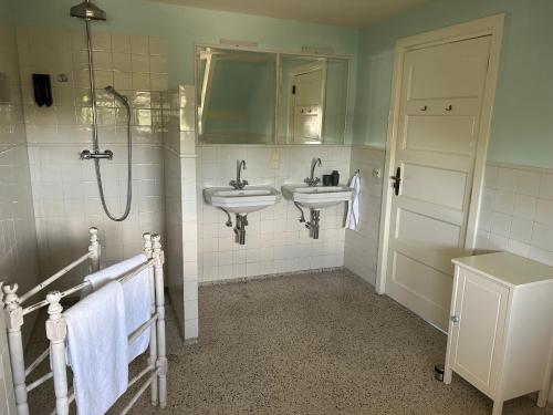 a bathroom with two sinks and a shower at Villa Nieuwland B&B in Den Oever