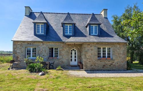 une ancienne maison en pierre avec un toit bleu dans l'établissement 4 Bedroom Awesome Home In Plouigneau, à Plouigneau