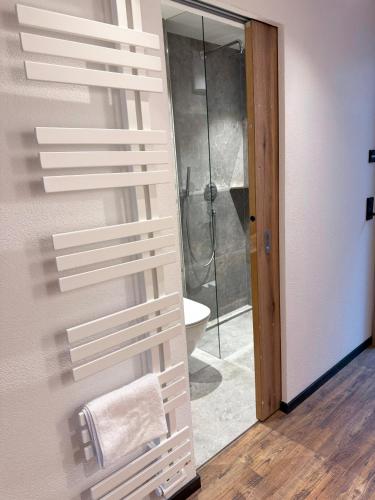 a bathroom with a shower with a towel on a wall at first mountain Hotel Zillertal in Aschau