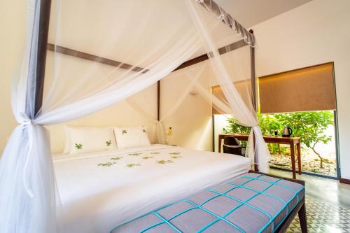 a bedroom with a bed with a canopy at Coco Luxury Villa Mũi Né in Ấp Thiện Phước