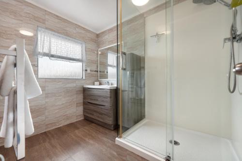 a bathroom with a shower and a sink at Travel Air Motel in Auckland