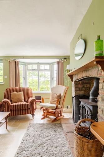 a living room with a fireplace and a couch at Fern Cottage Iden, Rye in Iden