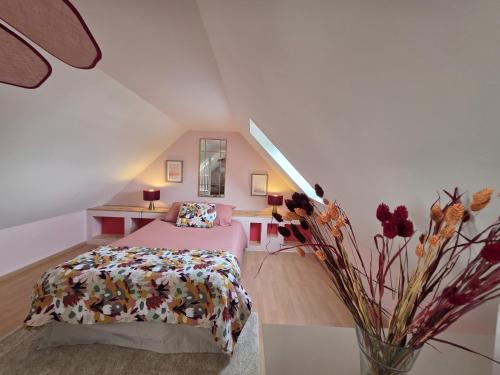 - une chambre avec un lit et un vase de fleurs dans l'établissement Charmante maison avec vue mer panoramique et acces direct aux magnifiques plages, à Plouguerneau