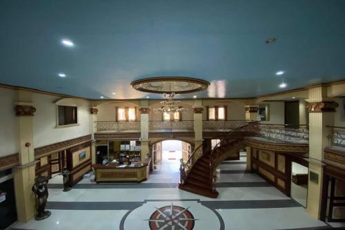a large lobby with a staircase and a chandelier at Garden Suite Hotel near Koreatown in Angeles
