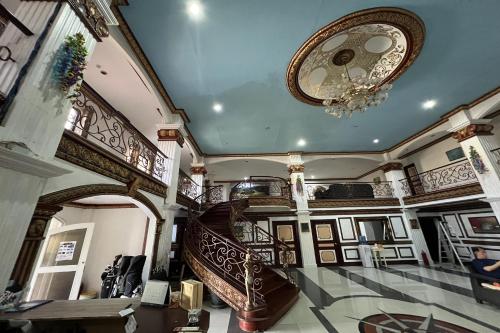 a large room with a staircase and a chandelier at Garden Suite Hotel near Koreatown in Angeles