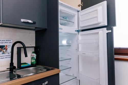 a refrigerator with its door open next to a sink at Casa Oslo in Grassobbio