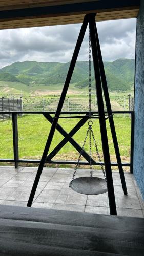 a swing in front of a window with a view at Shahdag Berghoff House in Qusar