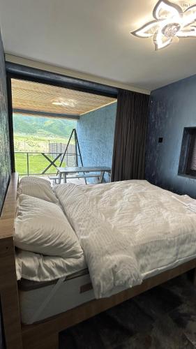 a large bed in a bedroom with a window at Shahdag Berghoff House in Qusar