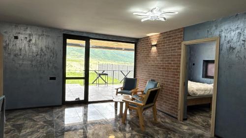 a room with a chair and a desk and a window at Shahdag Berghoff House in Qusar