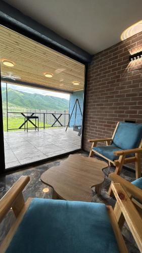 a room with two chairs and a table and a large window at Shahdag Berghoff House in Qusar