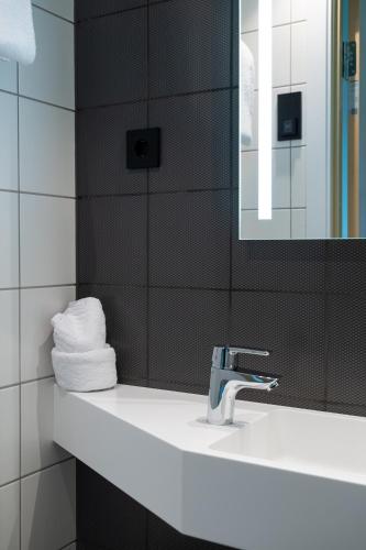 a bathroom with a sink and a mirror and towels at Citybox Kristiansand in Kristiansand