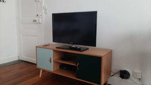 ein Flachbildfernseher auf einem Holzschrank in der Unterkunft T2 plein centre-ville, Gare à 5 min, Près Ermitage in Maisons-Laffitte