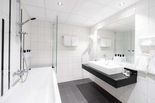 a white bathroom with a sink and a shower at Scandic Alexandra Molde in Molde