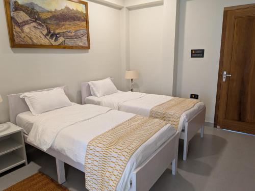 a room with two beds and a picture on the wall at GG in Imphal
