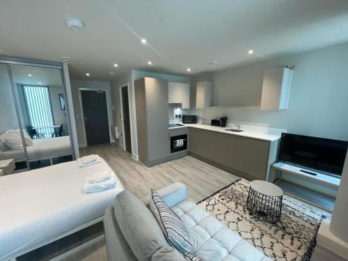 a living room with a white couch and a kitchen at Contemporary Studio with free Parking in Bracknell in Bracknell