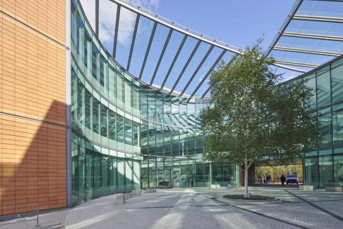 a glass building with a tree in front of it at Contemporary Studio with free Parking in Bracknell in Bracknell