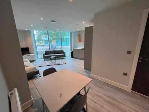 a living room with a table and a couch at Cosy Studio with private entrance & Parking in Bracknell
