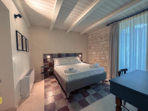 a bedroom with a bed and a desk in a room at Spighe e Fenicotteri in Modica