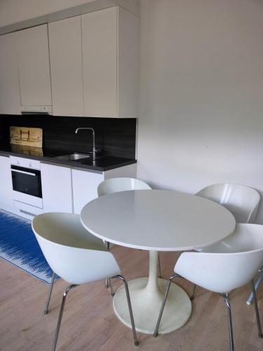 a white table and chairs in a kitchen at Apartment & BBQ & free parking in Espoo