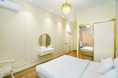 a bedroom with a white bed and a mirror at Radison Luxury Apartment Baku in Baku