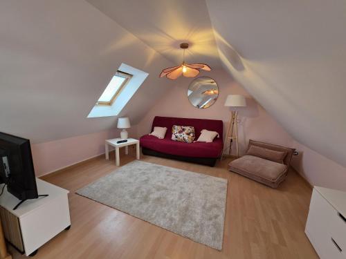 un salon avec un canapé rouge et une télévision dans l'établissement Charmante maison avec vue mer panoramique et acces direct aux magnifiques plages, à Plouguerneau