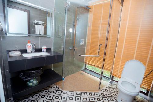 a bathroom with a shower and a sink and a toilet at Sunset Haven Villa - Venuestay in Sóc Sơn