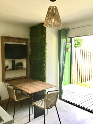 une salle à manger avec une table et des chaises dans l'établissement Garden T2 city center Free parking on site, à Dax