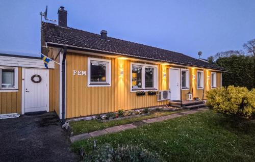 a yellow house with lights on the side of it at Cozy Home In Bomstermåla With Sauna in Blomstermåla