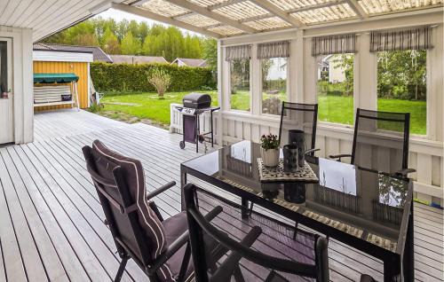 a screened in porch with a table and chairs at Cozy Home In Bomstermåla With Sauna in Blomstermåla