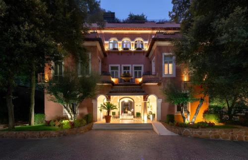 a large house with lights on it at night at Hotel Principe Torlonia in Rome