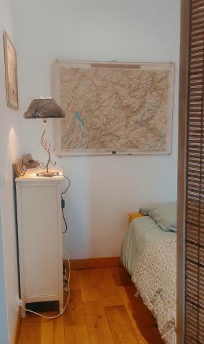 Cette chambre comprend un lit et une carte murale. dans l'établissement Appartement cosy, au calme, axe Annecy - Genève, à Villy-le-Pelloux