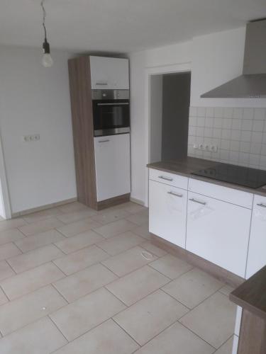 a kitchen with white appliances and a tiled floor at Gemütlich im bayerischen Dorf Nähe Starnberger See in Münsing am Starnberger See