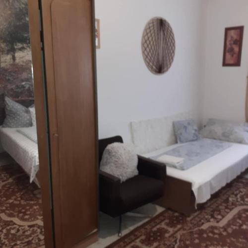a small bedroom with a bed and a chair at Faragó Vendégház in Abádszalók
