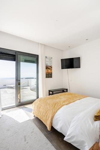 a bedroom with a large bed with a television on the wall at Bica Vista in Lourinhã