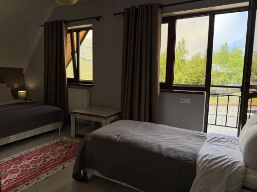 a bedroom with a bed and a large window at OISHE Boutique Hotel in Stepantsminda