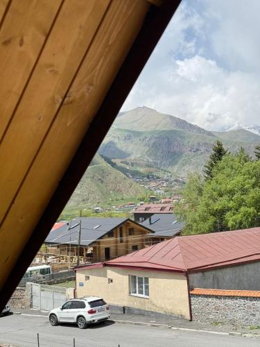 a car parked in a parking lot with mountains in the background at OISHE Boutique Hotel in Stepantsminda