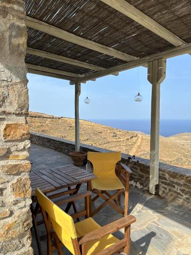 a patio with two chairs and a table with a view at Serenity Hill in Kithnos