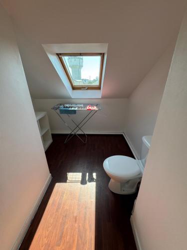 ein kleines Badezimmer mit Toilette und Fenster in der Unterkunft Appartement dernier étage terrasse et parking in Carantec