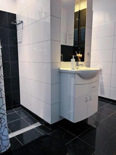 a white bathroom with a sink and a mirror at Dom nad Jeziorem in Sajzy