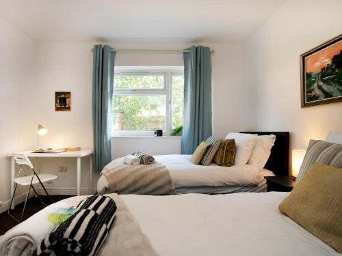 a bedroom with two beds and a window at Pass the Keys Bright & Cosy Home with Garden Free Parking in Nottingham