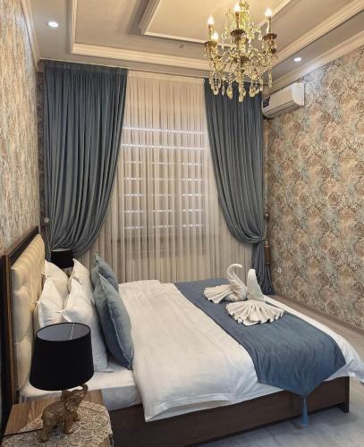a bedroom with a large bed with a chandelier at Art Apart Residence in Tashkent