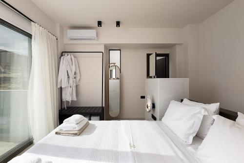 a bedroom with a large white bed and a window at Dea Luna Villas, Heated Pool & 5star Resort Access, By ThinkVilla in Panormos Rethymno