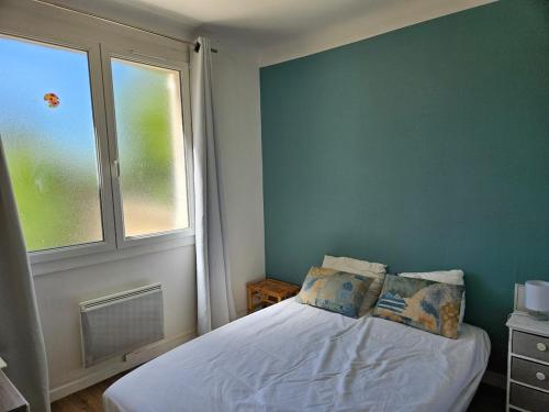 - une chambre avec un lit avec deux oreillers et une fenêtre dans l'établissement Appartement au calme, à Sarrians
