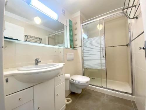 une salle de bain avec un lavabo, des toilettes et une douche dans l'établissement Charmant Appartement Rénové pour 5 Personnes – Résidence avec Piscine et Parking – La Grande Motte, à La Grande Motte